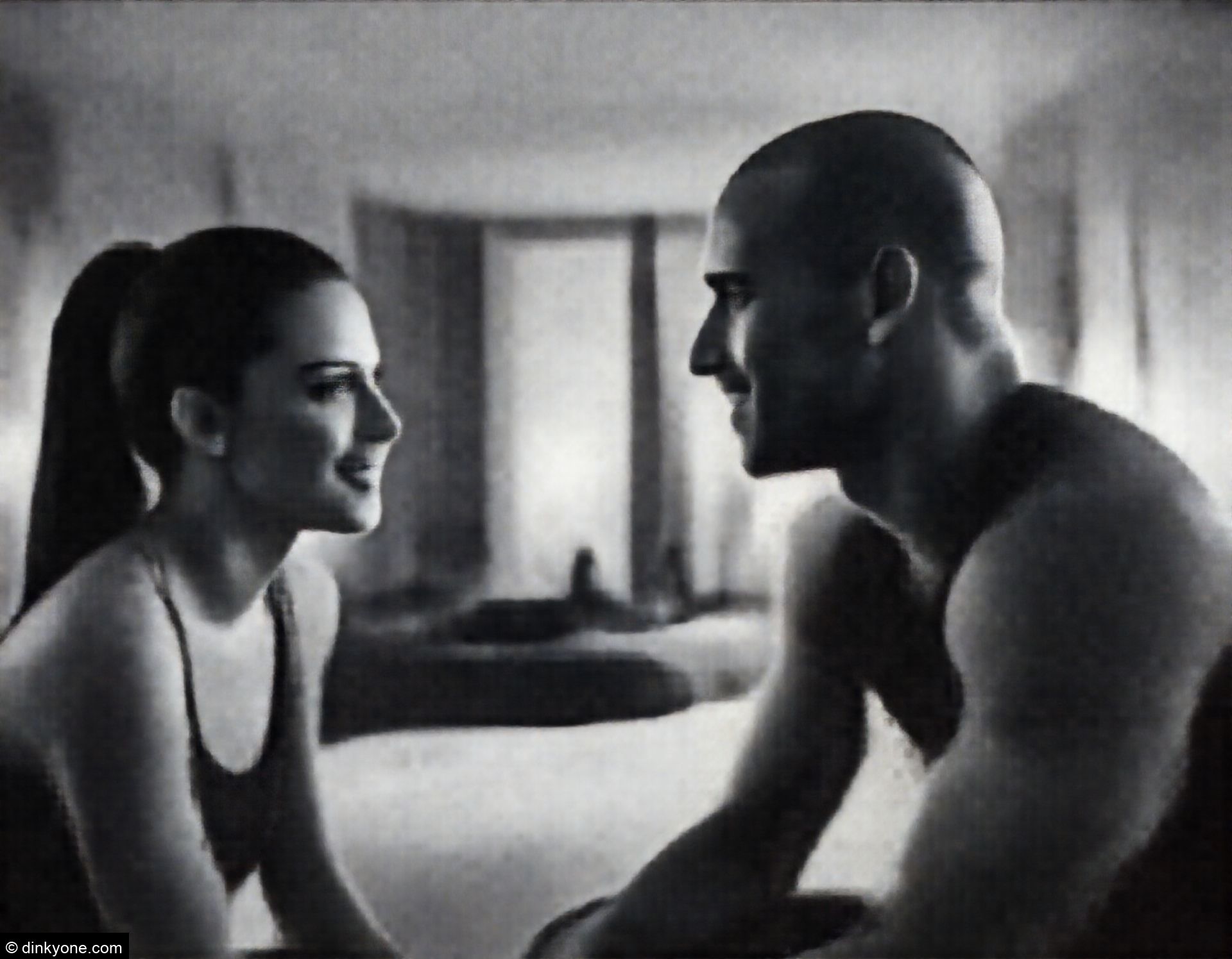 An athletic couple in a modern loft bedroom with ambient lighting.