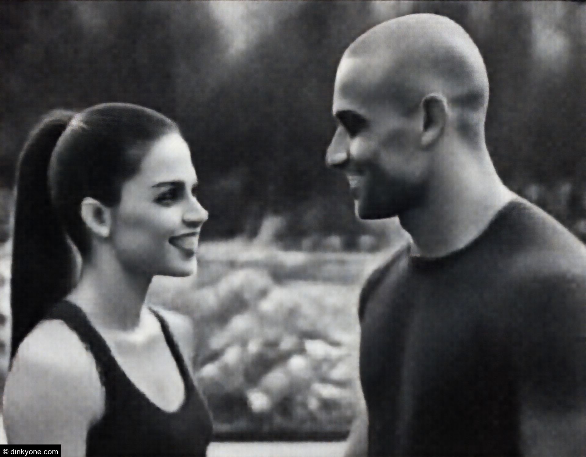 An athletic couple in a public garden with flower displays.