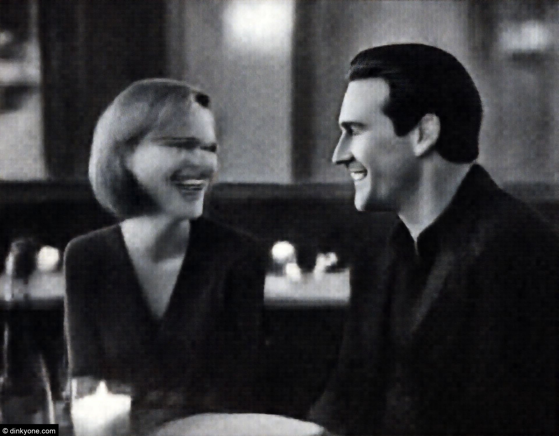 A couple in a cosy wine bar with candlelit tables.