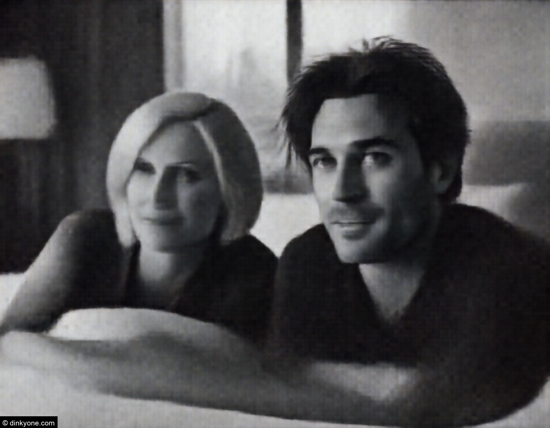 A couple in a luxury hotel suite with city views.