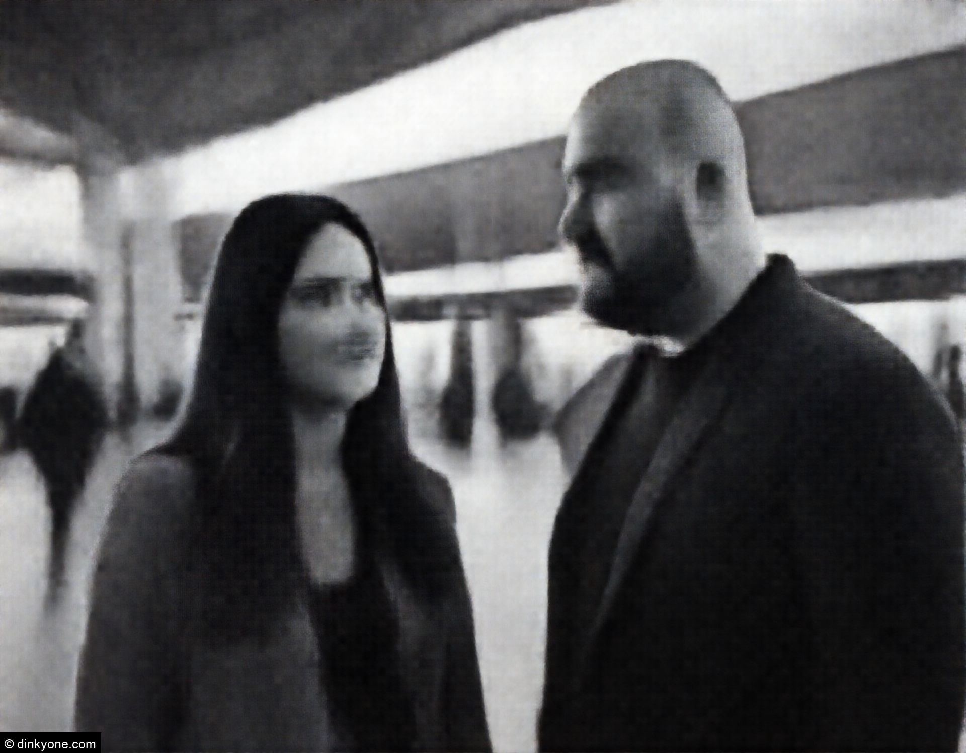A couple at a train station concourse with modern architecture.