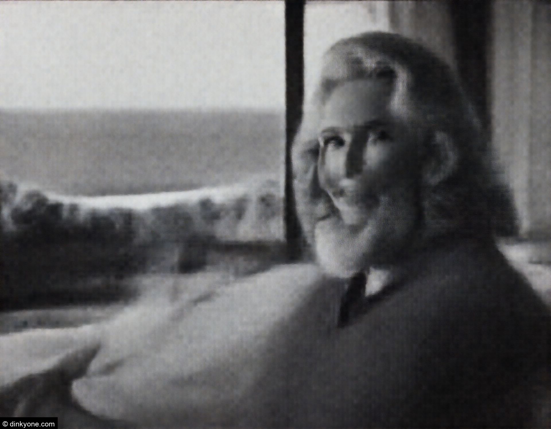 An older couple in a high end resort bedroom overlooking the ocean.