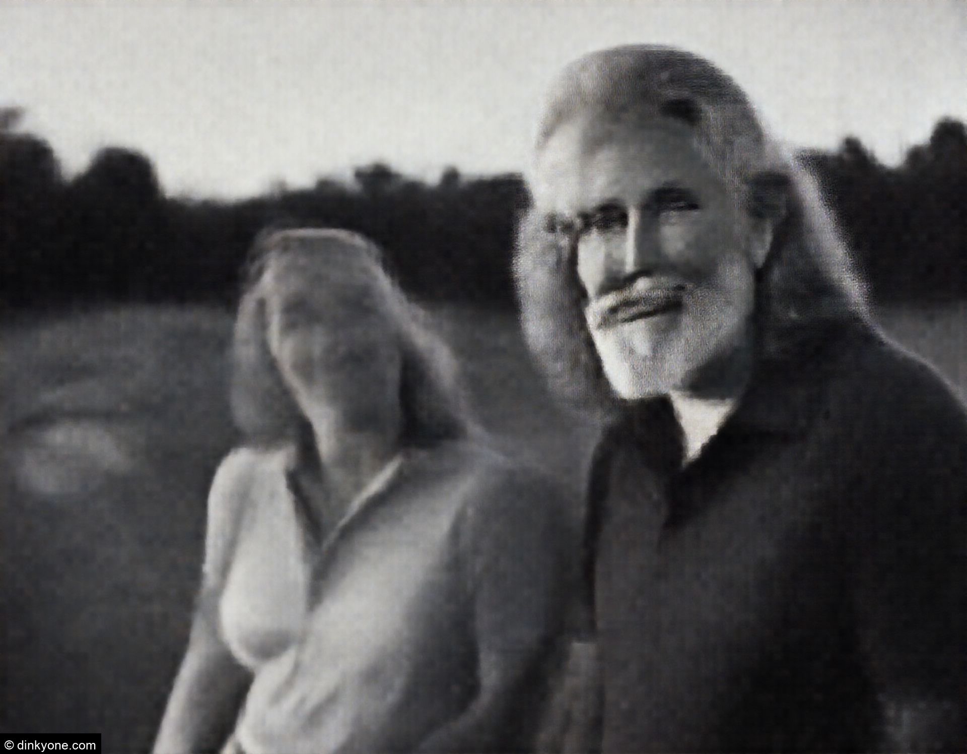 An older couple at a mini golf course on a summer evening.