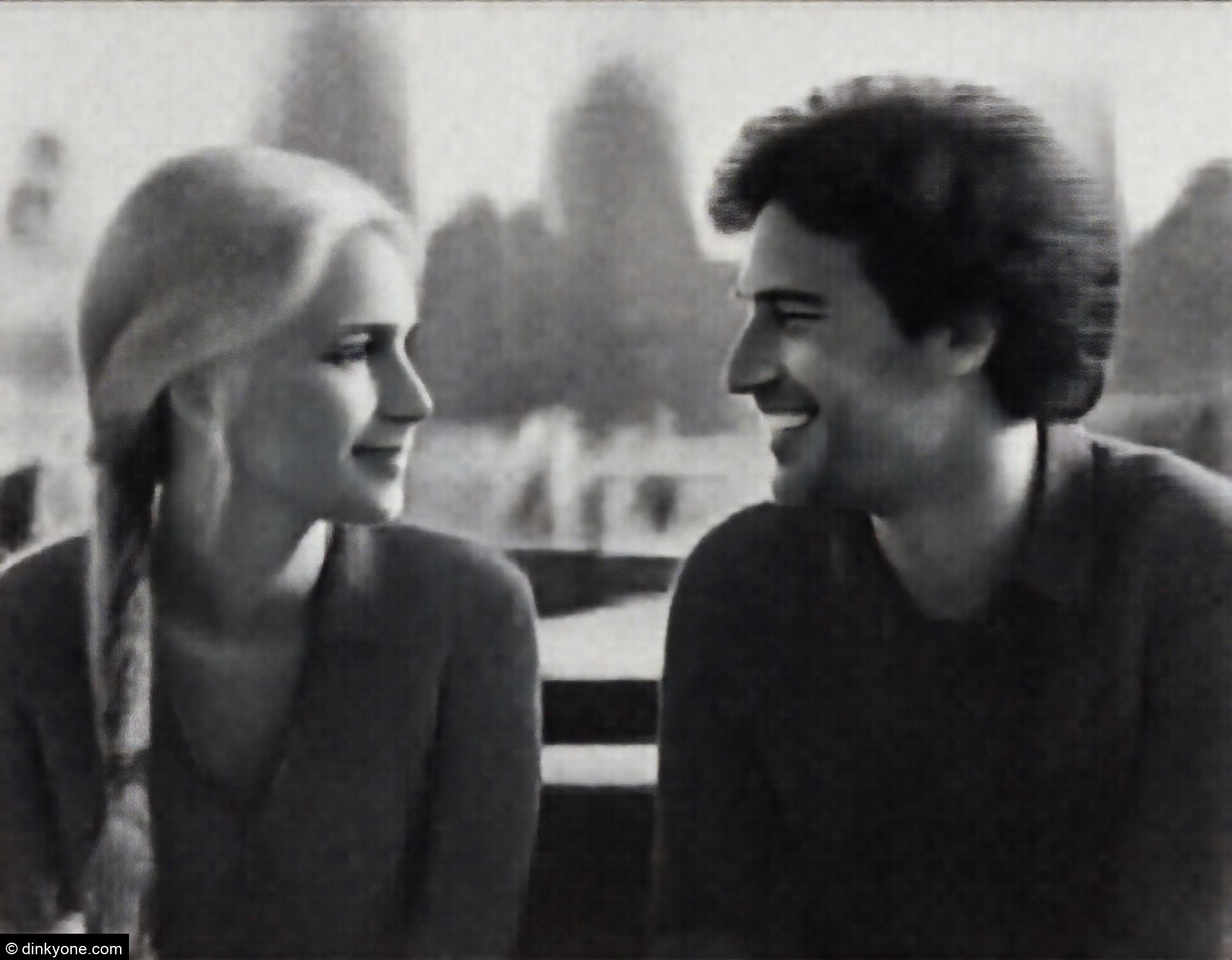 A relaxed couple at a rooftop cafe overlooking the city skyline.